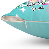A close-up of a turquoise throw pillow with a printed graphic featuring the phrase 'talk tiles to me' in black script, white stars, and pastel tropical floral accents. The zipper is open, showing a cream-colored inner lining, set against a plain white background.