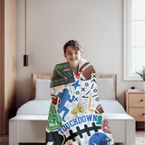a boy wrapped in a football themed throw blanket. 