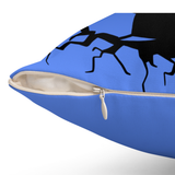 A close-up of a blue throw pillow with a black abstract graphic print and a partially unzipped front pocket showing a cream-colored lining.