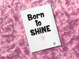 back cover of a journal, white with black text that says 'BORN TO SHINE' with a pink heart. 