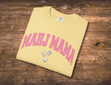  a yellow Comfort Colors t-shirt that says 'MAHJ MAMA' in a pink, distressed, varsity arched font. 3 Mahjong tiles underneath. 