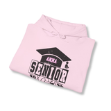 A folded light pink hoodie with a black and pink graduation cap graphic that reads 'ANNA SENIOR 2026' on a white background.