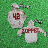 Two heather gray hoodies laid flat, labeled Front and Back. The front hoodie shows the number 42 in distressed red and the back hoodie shows the word ZOPPEL in distressed red across the shoulders.