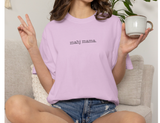 A woman wearing a light pink short-sleeve t-shirt with the text 'mahj mama.' printed in black across the chest.