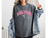 Woman  wearing a grey Comfort Colors t-shirt that says 'MAHJ MAMA' in a pink, distressed, varsity arched font. 3 Mahjong tiles underneath. 