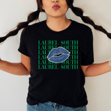 A person wearing a black graphic T-shirt with the text 'LAUREL SOUTH' repeated in green and a blue lip print across the center, paired with blue jeans against a plain light background.