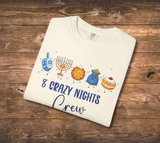  a cream-colored graphic t-shirt with a Hanukkah-themed design that reads '8 CRAZY NIGHTS Crew' and features cartoon illustrations of a driedel, menorah, latke, gelt and donut.