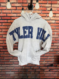 Grey hoodie sweatshirt with camp name 'TYLER HILL' in varsity, distressed letters huge across the chest going out onto the arms. 