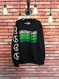 black crewneck sweatshirt with camp name 'chestnut lake' in a wavy retro font, written across the chest 4 times going from white, light green, neon green and green. there are 4 white peace signs going down one arm. 