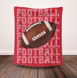 Red blanket with 'FOOTBALL' on repeat going down the whole blanket, a big football in the center with the name 'SAMSON' on the ball in white. 