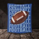 Blue blanket with 'FOOTBALL' on repeat going down the whole blanket, a big football in the center with the name 'SAMSON' on the ball in white. 