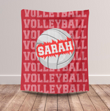 red throw blanket with text 'VOLLEYBALL' on repeat down the whole blanket. A big white volleyball in the center, with a name going through the ball. 