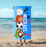 Personalized towel with sports-themed design and name 'Michael' with a blue background being held up on the beach. 