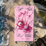 Pink beach towel with disco cherries and 'Tyler Hill Pool Club' text 