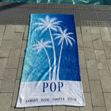 A blue ombre towel that has 'POP' with the 4 grandkids names at the bottom. 