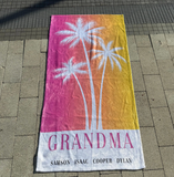 A pink and yellow ombre towel that has 'GRANDMA' with the 4 grandkids names at the bottom. 
