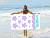 A girl holding a towel with lavender daisies and the name 'HANNAH' at the bottom of the towel. 