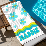 Towel with turquoise daisies and the name 'MADDIE'. 