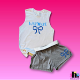 White tank top with cursive text 'WESTMONT' and bow underneath, grey shorts with matching bow. 