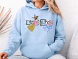 Light blue hoodie with ransom style decorative text spelling out a camp name, with a leopard print star, blue bow and glittery gold heart. 