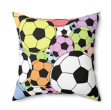 A square throw pillow featuring a colorful pattern of soccer balls in various colors including yellow, pink, green, orange, black, and white, set against a clean white background.
