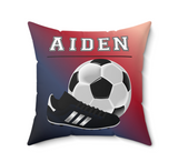 A square decorative throw pillow with a red-to-blue gradient background, featuring the name 'AIDEN' in white block letters above a soccer ball and a black cleat graphic. The pillow is shown on a plain white background.