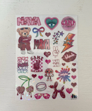 A sheet of holographic stickers featuring various designs including the word 'MAYA' in pink, a teddy bear in sweatpants, hearts, bows, stars, a lightning bolt, cherries, sunglasses, and other cute graphics, displayed on a white wood-textured background.