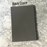 A dark gray notebook back cover with a black spiral binding, shown on a white and gray marble-patterned background with the text 'Back Cover' at the top.